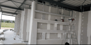 Chantier intérieur : pose de plaques de plâtre et enduisage sur ossature métallique pour cloison avec niches intégrées.